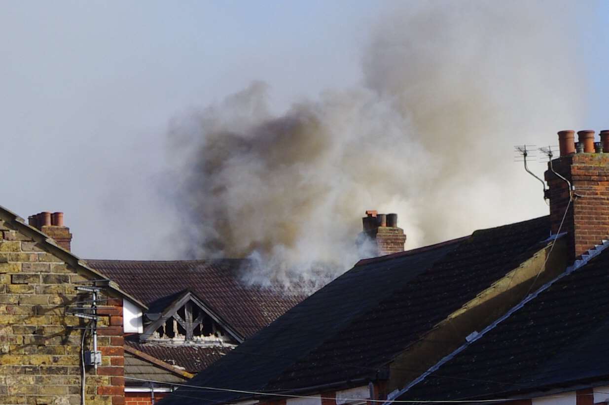 Smoke erupts from the burning building