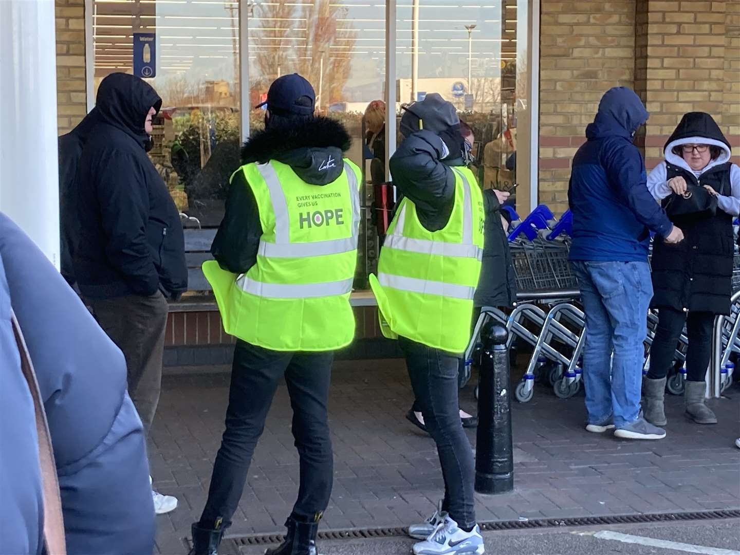 Staff check the Covid booster jab queue which stretched around Tesco supermarket in Bridge Road, Sheerness