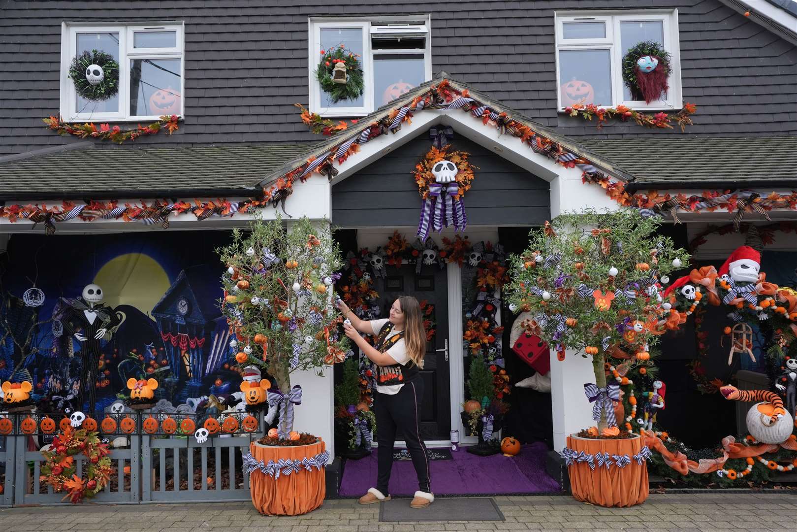 Lavinia Hedges puts the finishing touches to a Nightmare Before Christmas-themed Halloween display, which raises funds for the My Shining Star charity, at her home in Gillingham, Kent (Gareth Fuller/PA)