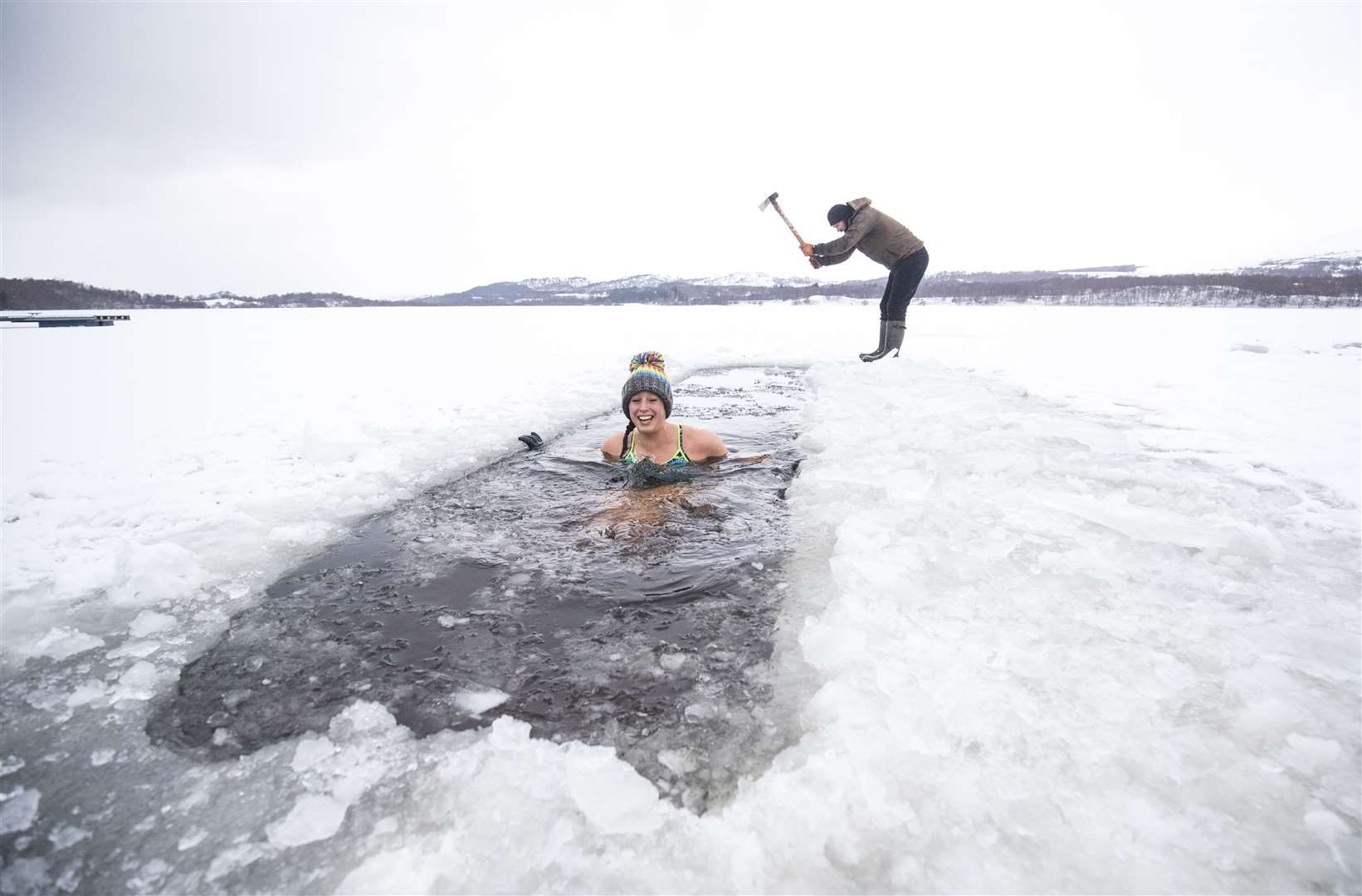 An axe was used to create a channel in the ice for hardy ice swimmers in Loch Insh, in the Cairngorms National Park (Jane Barlow/PA)