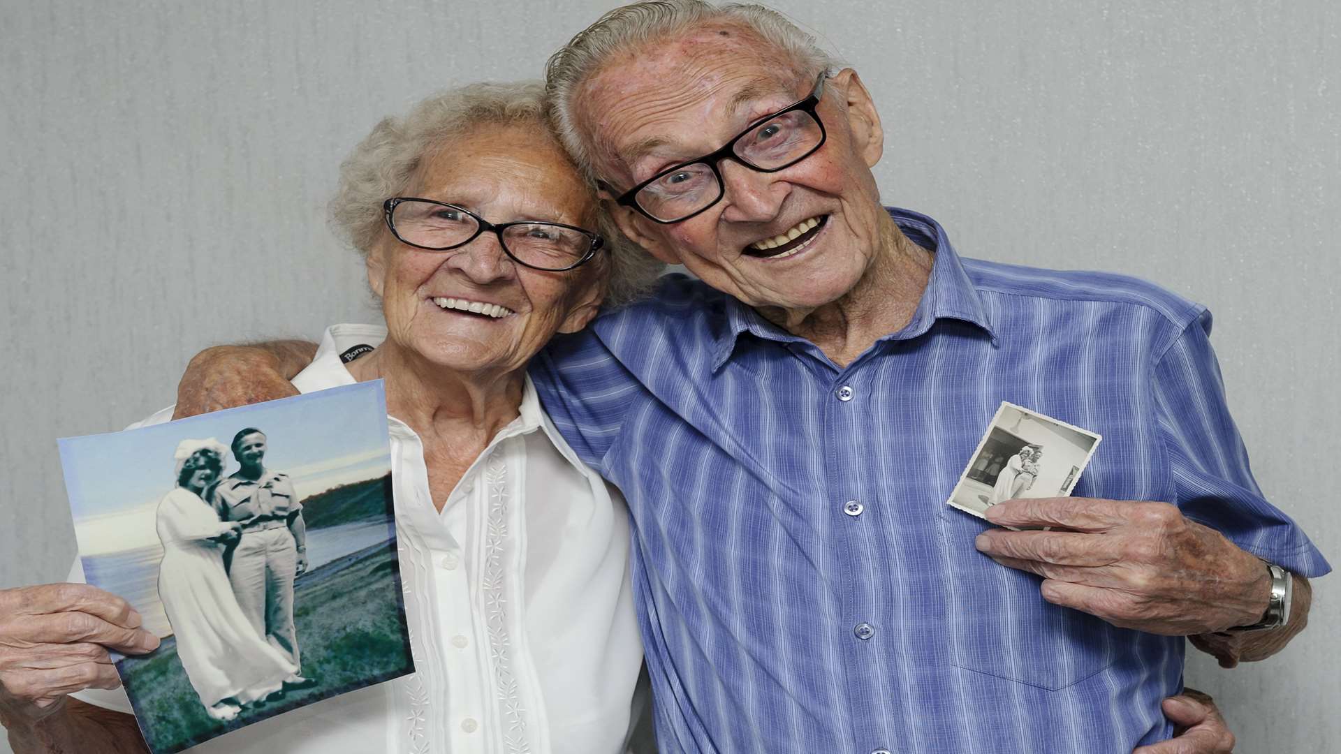 Mabel and Peter with pictures from their wedding.