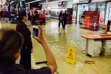 Staff at a supermarket in Northfleet take pictures as flood water rushes in. Picture: Kent_999s