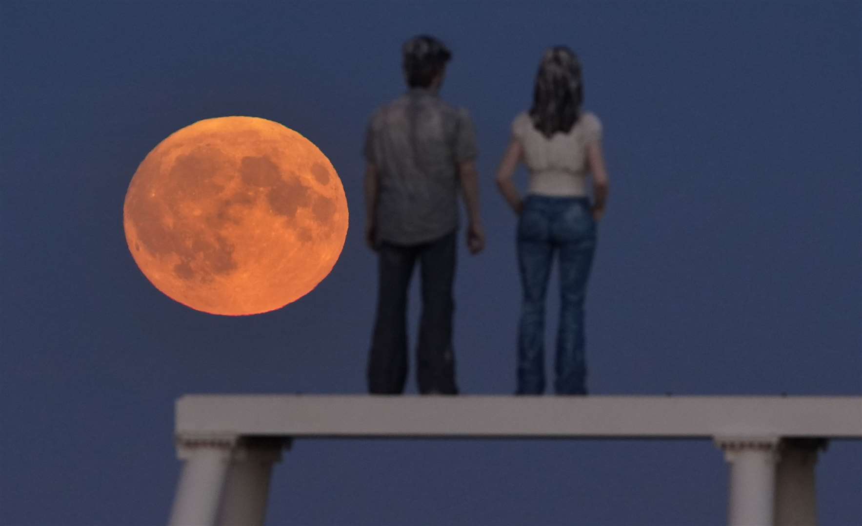 The supermoon over The Couple sculpture at Newbiggin-by-the-Sea in Northumberland (Owen Humphreys/PA)