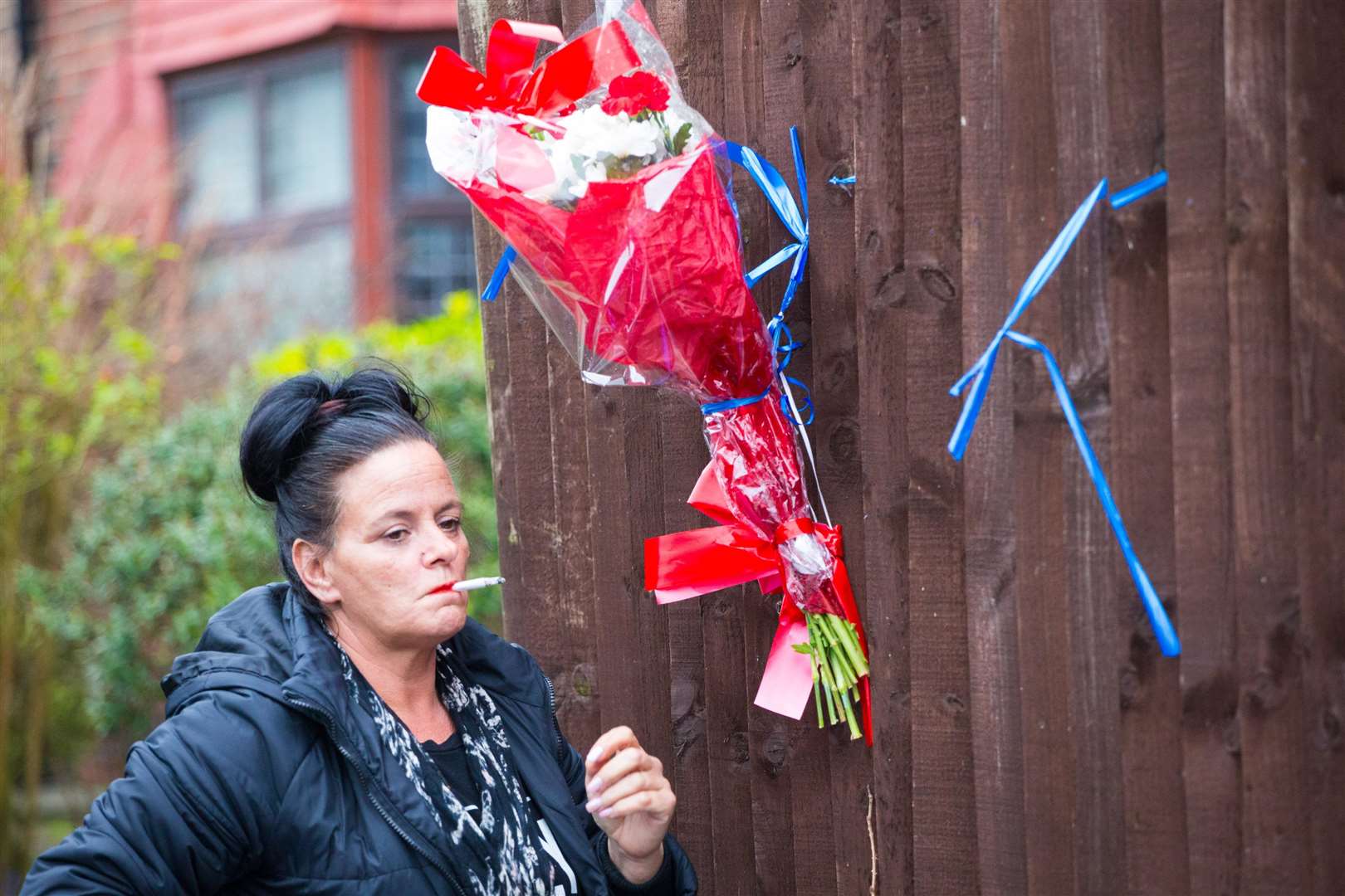A woman takes a break at the tribute area to burglar Henry Vincent. Pictures: SWNS (1454726)