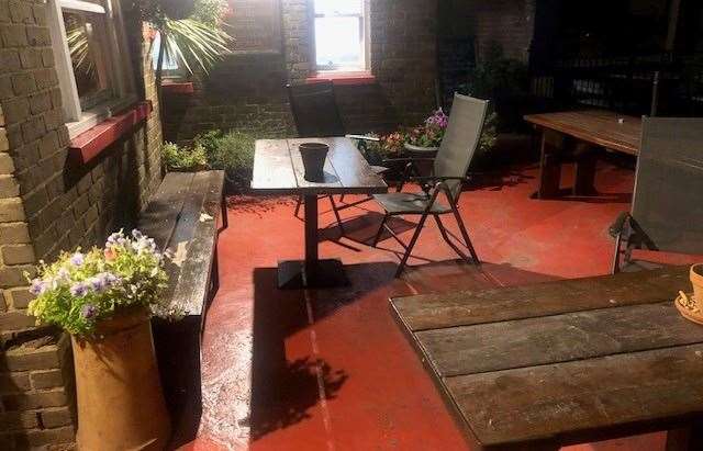 With its painted red floor and potted flowers, this area with a few table and chairs can be found at the front right of the pub