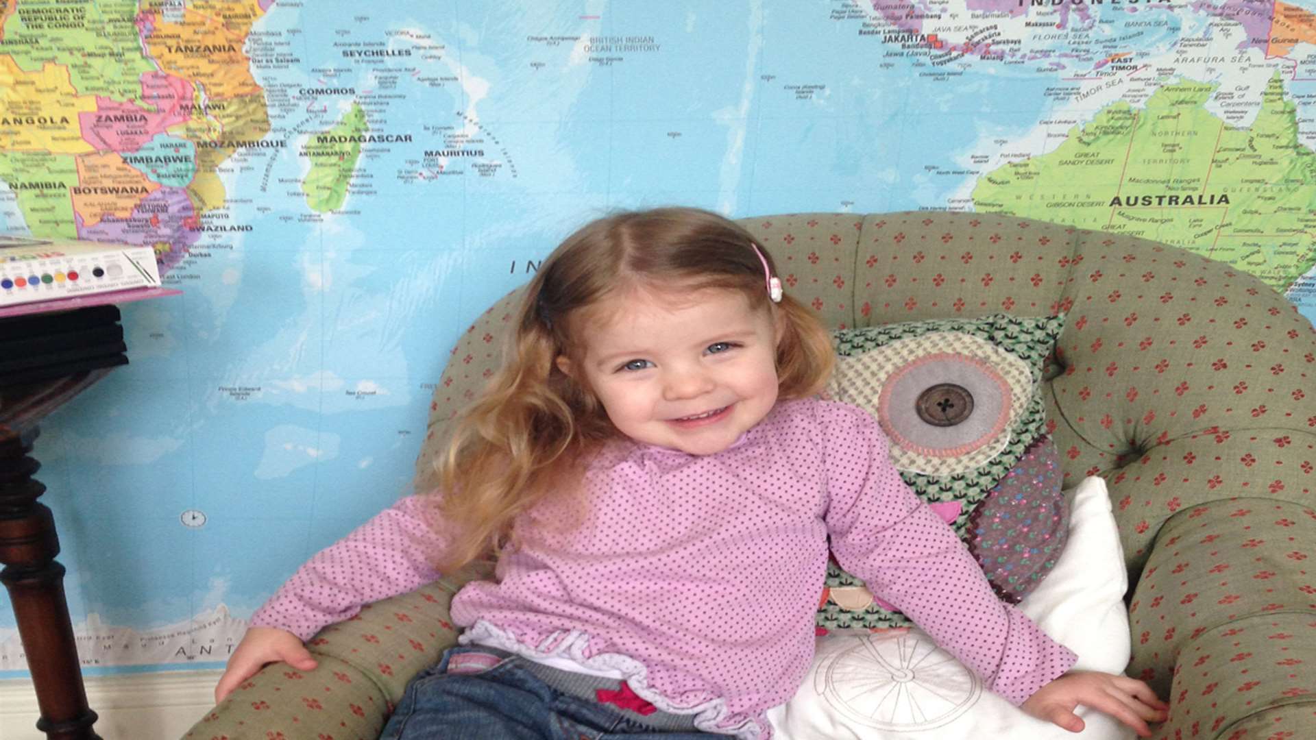 Richard's daughter Genevieve in front of their map feature wall