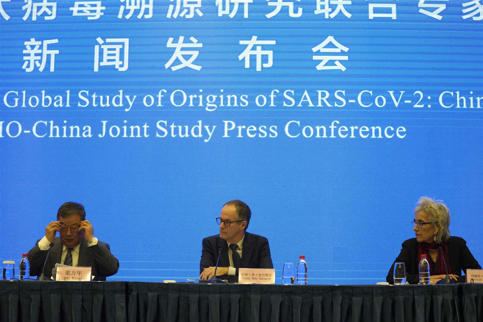 Marion Koopmans, right, and Dr Peter Ben Embarek, centre, of a World Health Organisation team, with their Chinese counterpart Liang Wannian, left, during a WHO-China Joint Study press conference in Wuhan (Ng Han Guan/AP)