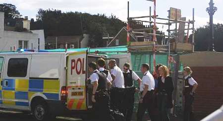 Police escort the man away. Picture: JOHN WESTHROP