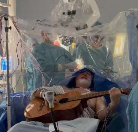 Colin Miller, from Herne Bay, played chords during the eight-hour procedure so that doctors could ensure he kept mobility in his hand and fingers. Picture: Brain Tumour Research