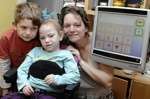 Elke Wisbey, six, with mum Glynnis and brother Galahad, eight, trying out her Smartbox. Picture:Matthew Reading