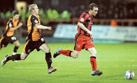 Charlie Lee strides away from the Barnet defence