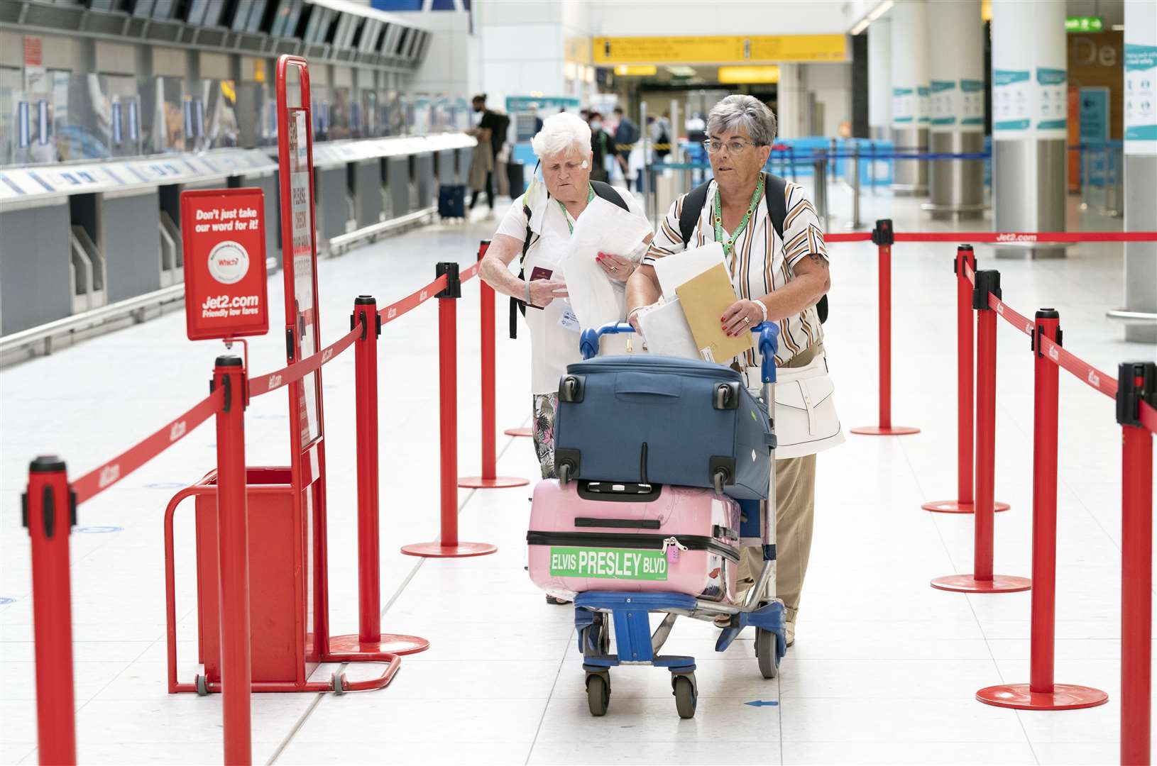 Two women head to a check-in desk at Glasgow Airport (Jane Barlow/PA)