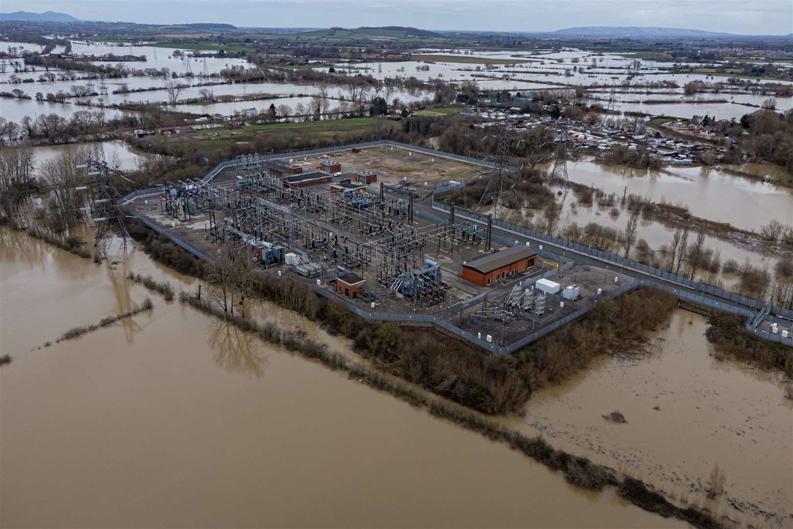 Flood water surrounds a power grid sub-station in Gloucester (Ben Birchall/PA)