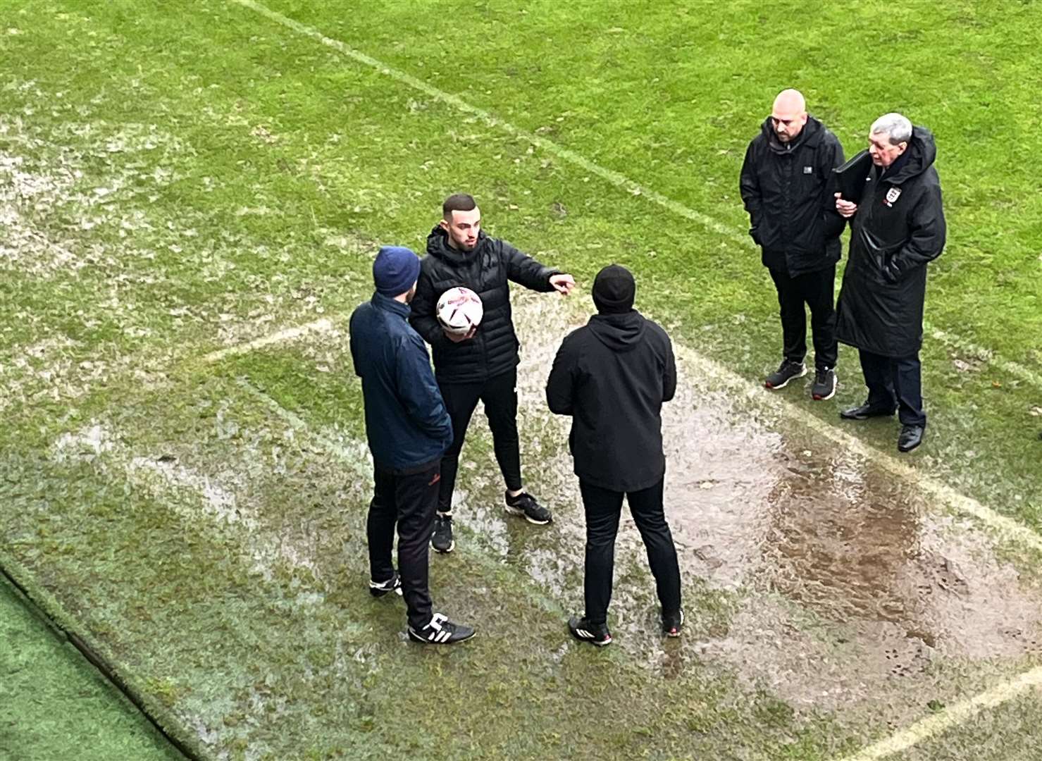 Referee Adam Merchant breaks the news to Salisbury boss Brian Dutton and Maidstone manager George Elokobi.