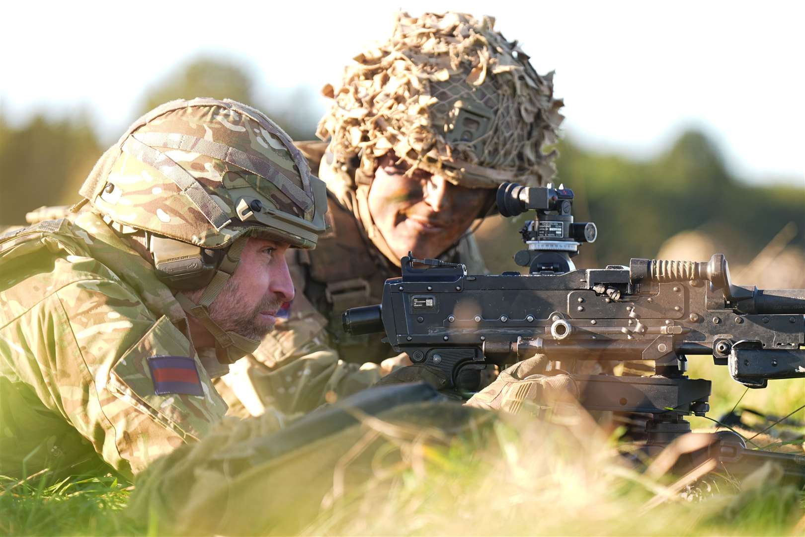 The Prince of Wales (left) tries out a general-purpose machine gun (Aaron Chown/PA)