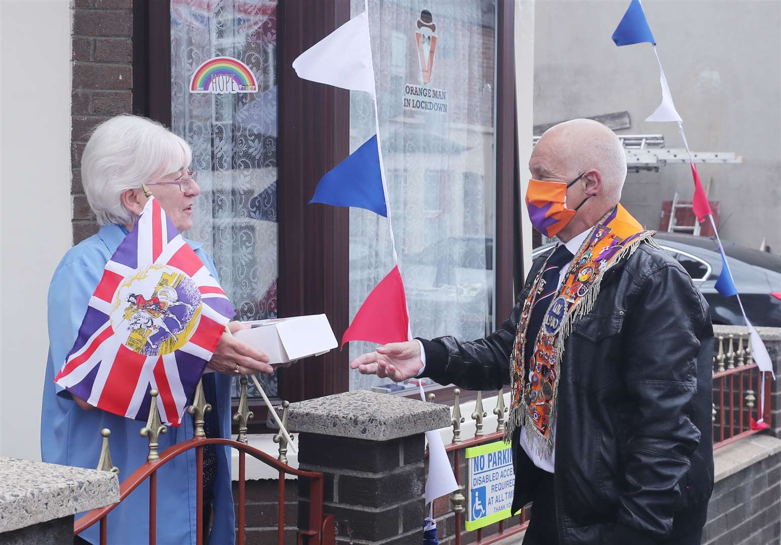 East Belfast resident Ruth Girvan receives a lunch box from Orangeman, Brian McKee (Niall Carson/PA)