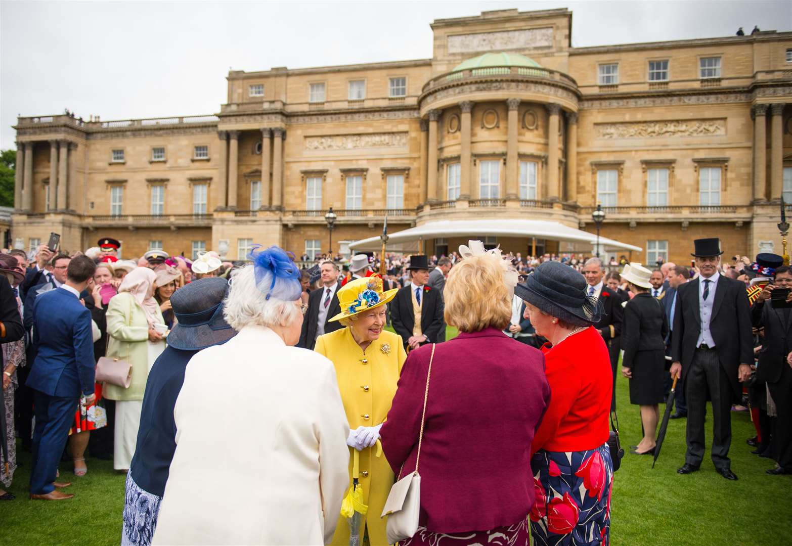 The Queen greets guests at a Buckingham Palace garden party (Dominic Lipinski/PA)