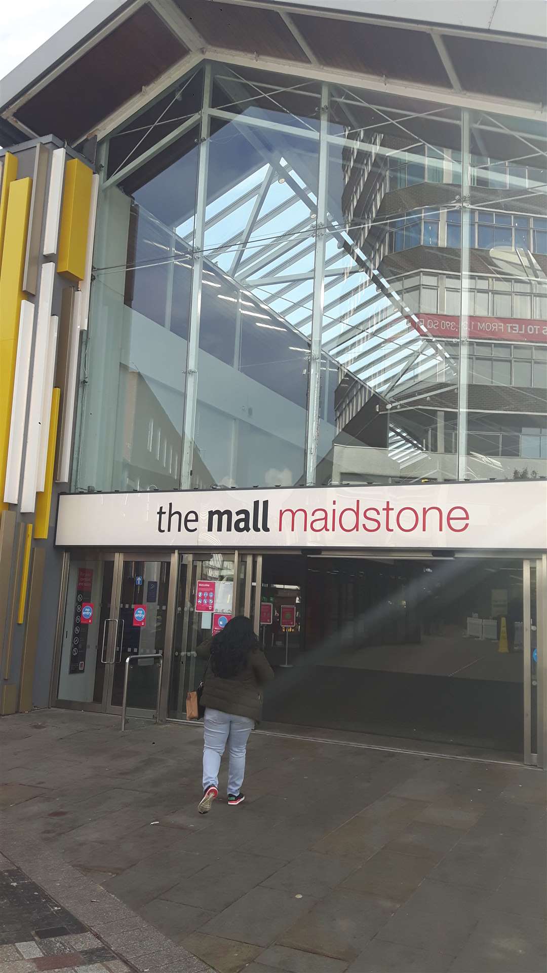 A solitary shopper enters The Mall