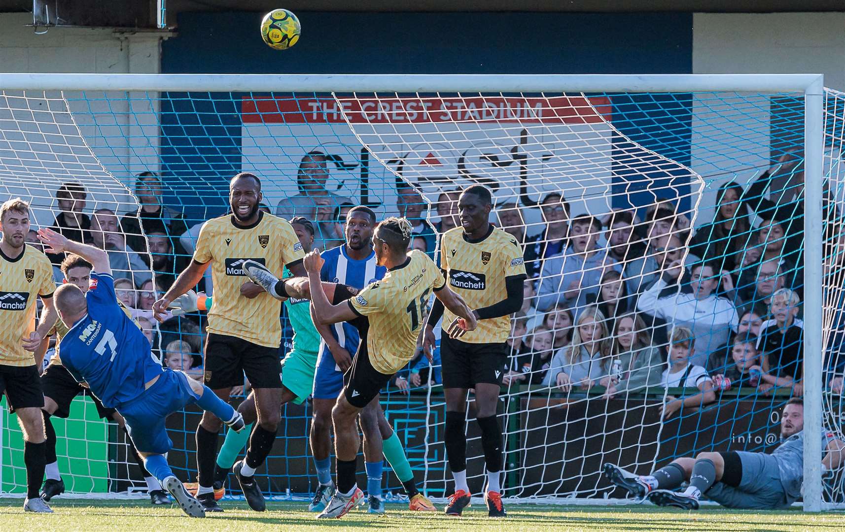 Maidstone substitute Matt Bentley cannons an attempted clearance against Herne Bay's Scott Heard and the ball goes over for a goal kick - while Herne Bay keeper Harry Brooks watches on from inside the Maidstone net. Picture: Helen Cooper