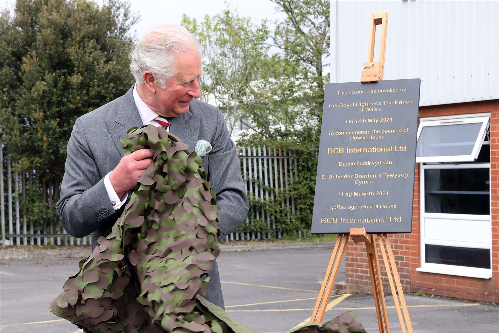 The Prince of Wales unveils a plaque to officially open the new headquarters during a visit to BCB International (Chris Jackson/PA)