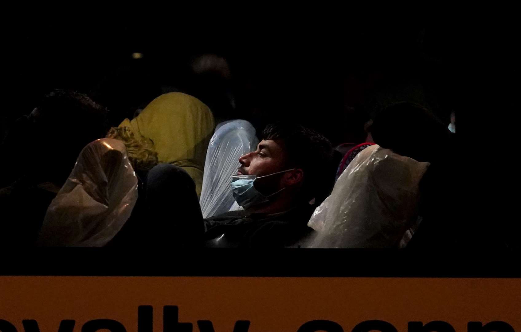 A group of people thought to be migrants wait to be transported onboard a coach after being brought in to Dover, Kent, following a small boat incident Channel (Gareth Fuller/PA)