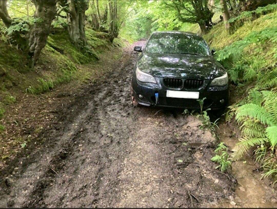 A BMW was found abandoned in a wooded area off Hamstreet Road – but became stuck in the mud. Picture: Kent Police