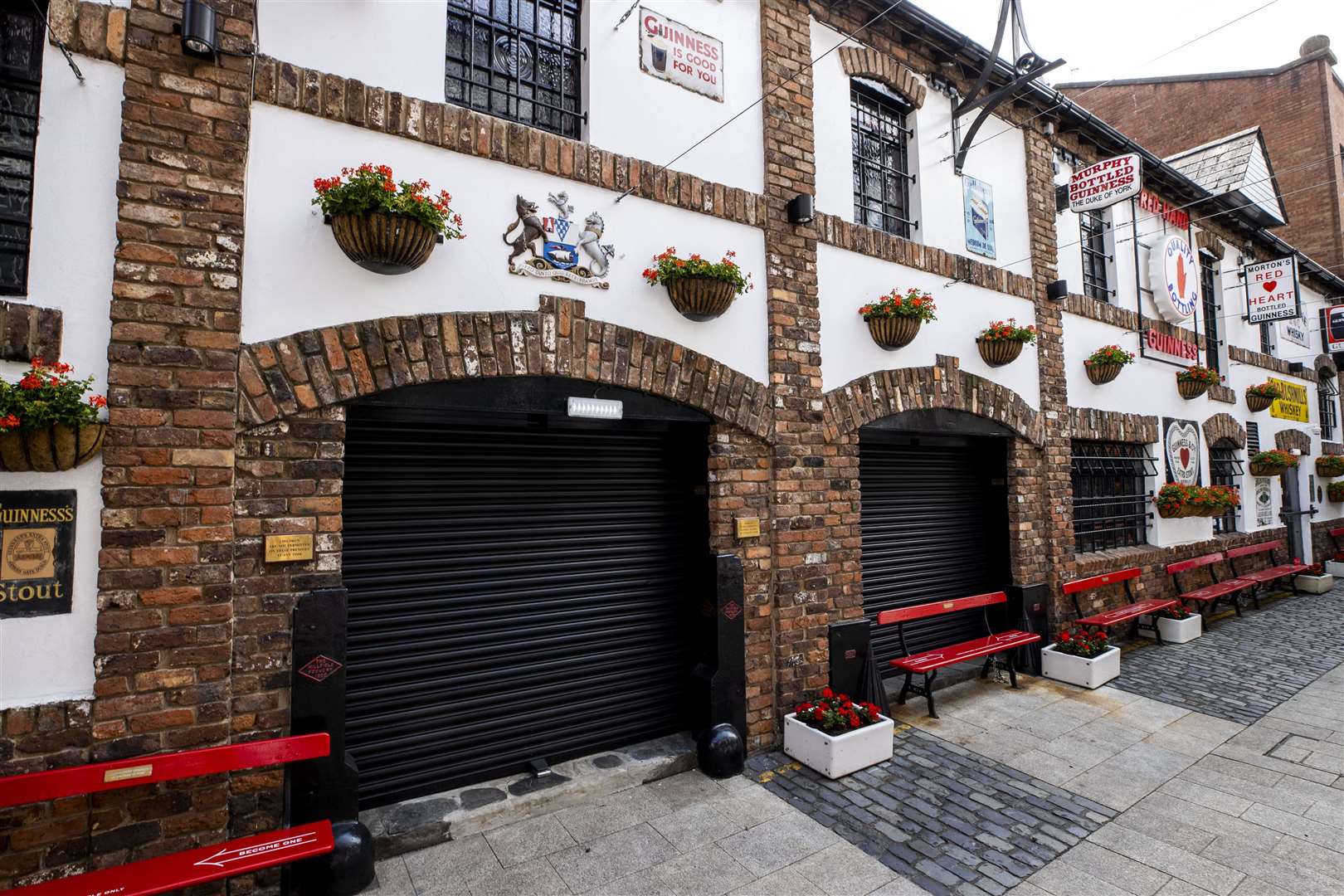 The Duke of York Bar, on Commercial Court in Belfast where the bar owner has put quirky social-distancing messages of the benches outside the bar (Liam McBurney/PA)