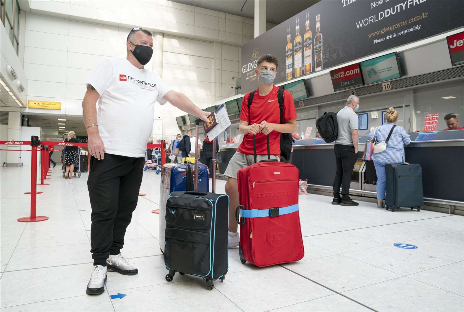 Brian Smith and his son Dillon wait at the Jet2 check-in desk (Jane Barlow/PA)