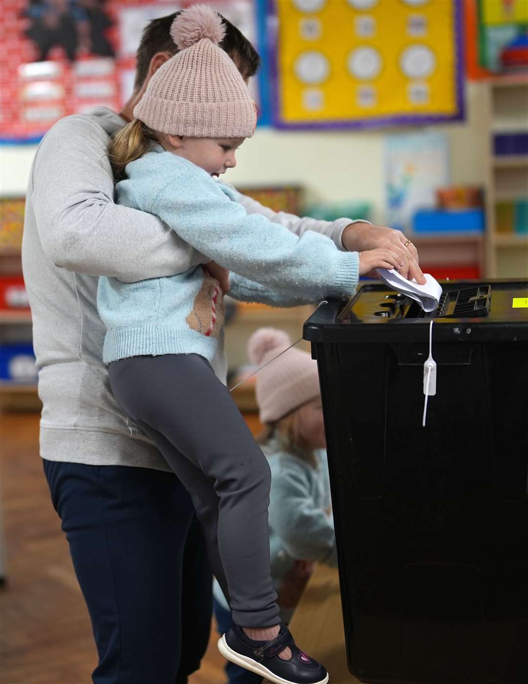 A young girl helps put a vote in the ballot box at St Anthony’s Boys’ School, Beechwood Park, Ballinlough, in Cork (Jacob King/PA)