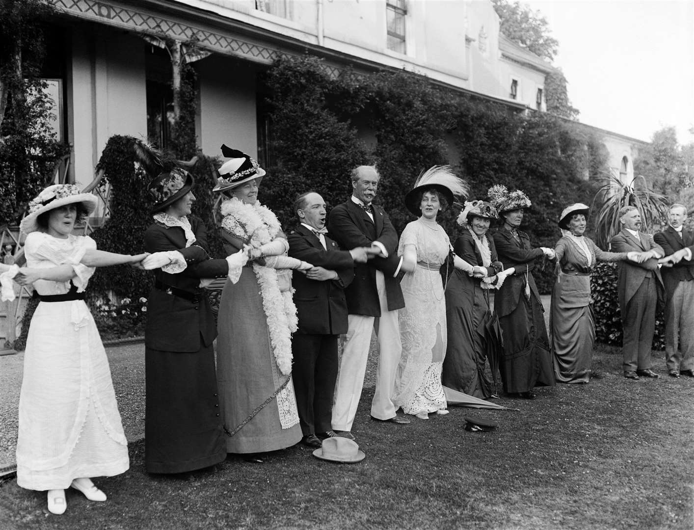 Scottish singer Harry Lauder, fourth left, and merchant Sir Thomas Lipton, fifth left, singing Auld Lang Syne with others (PA)