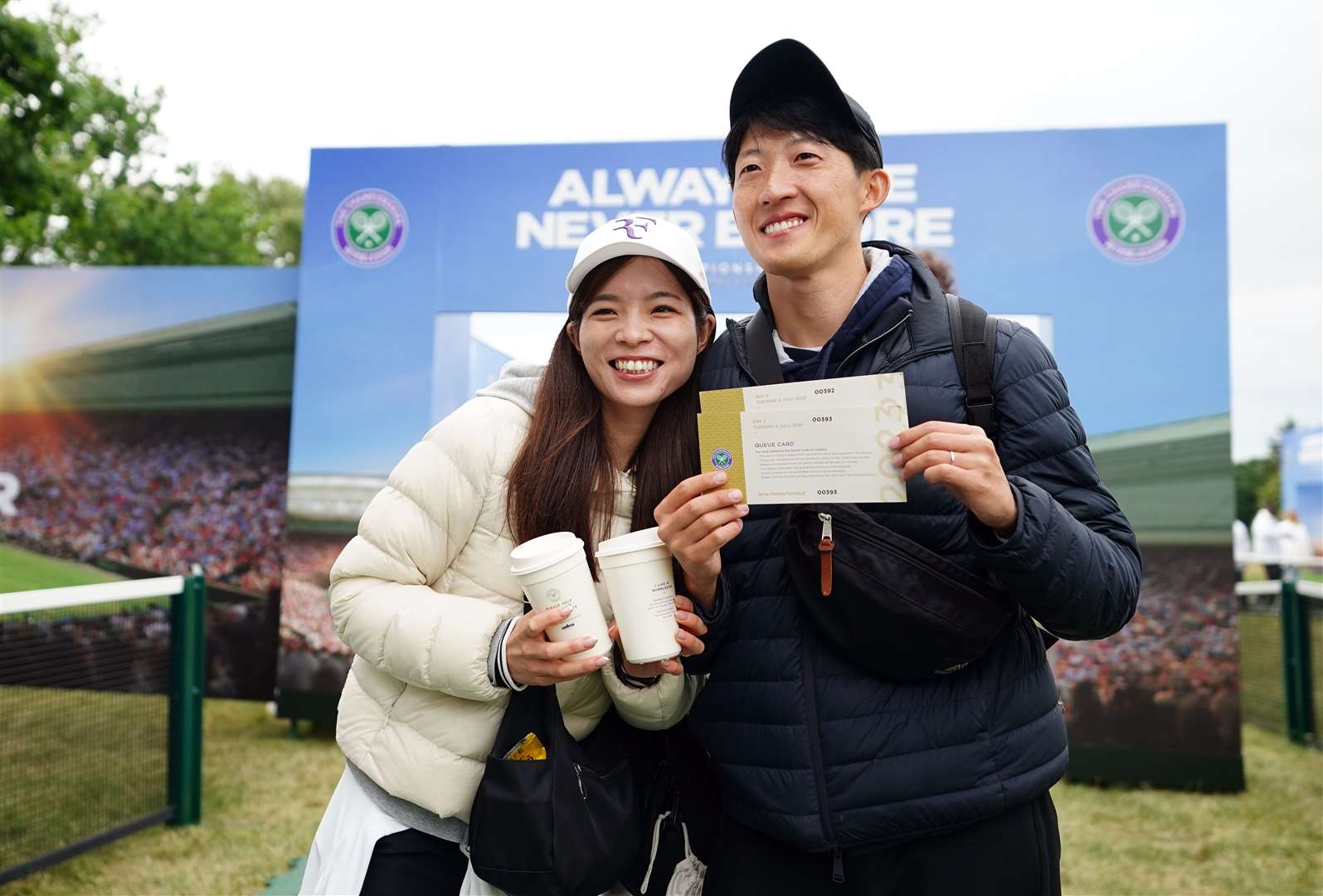 Two delighted fans pose with their tickets after gaining admission (Zac Goodwin/PA)