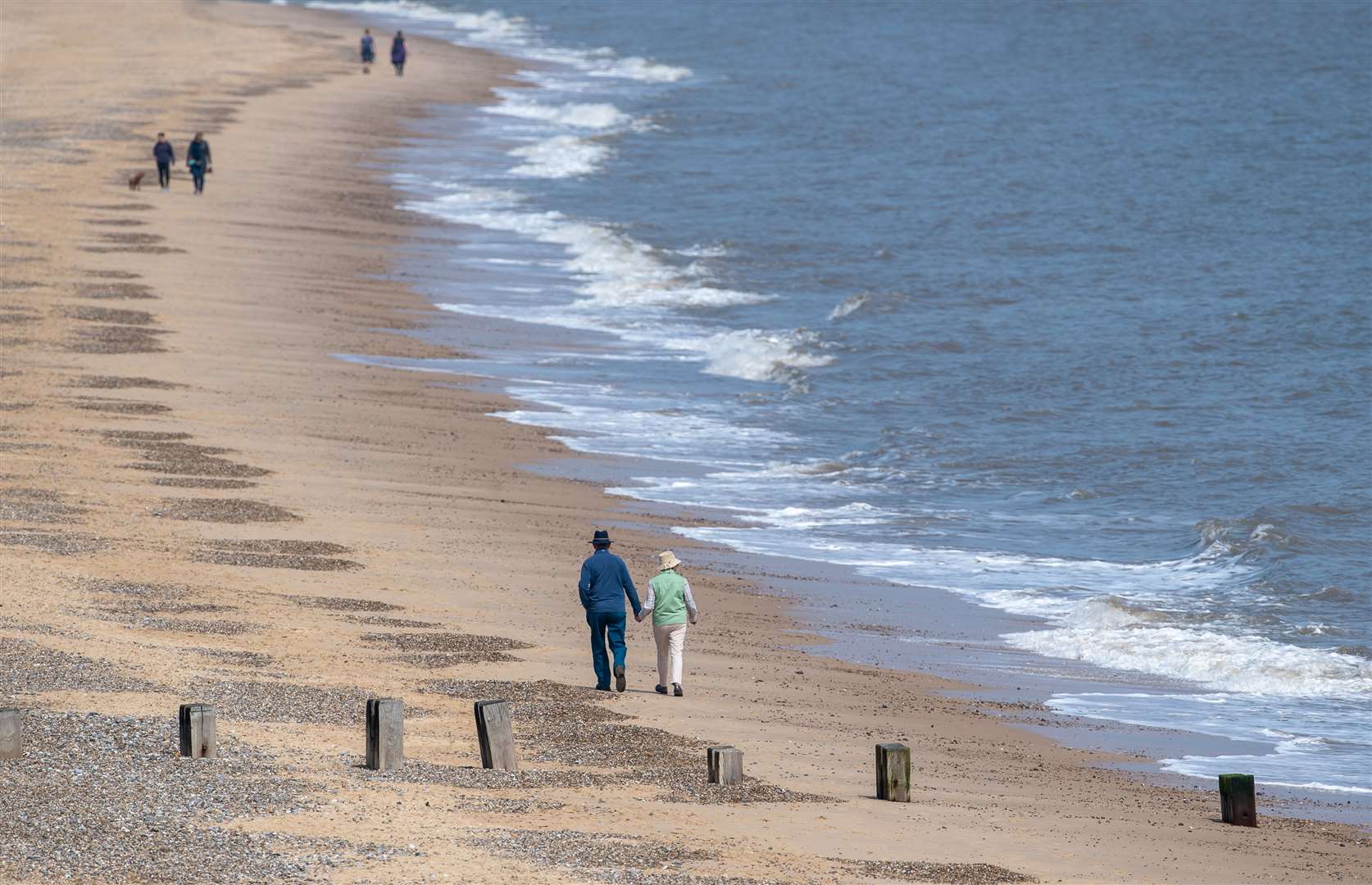 People social distancing as they walk along the beach at Gorleston-on-Sea in Norfolk (Joe Giddens/PA)