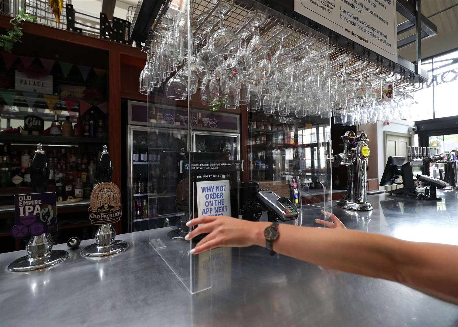 A protective shield for customers surrounds the card payment machine at the bar of The Mossy Well in Muswell Hill, London, ahead of pubs reopening on July 4 (Yui Mok/PA)