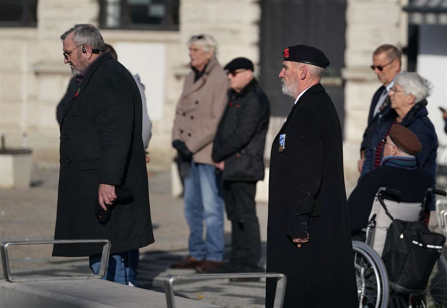 People stand by the First World War Soldier statue in Market Square in Dover for a two-minute silence to mark Armistice Day in Dover (Gareth Fuller/PA)