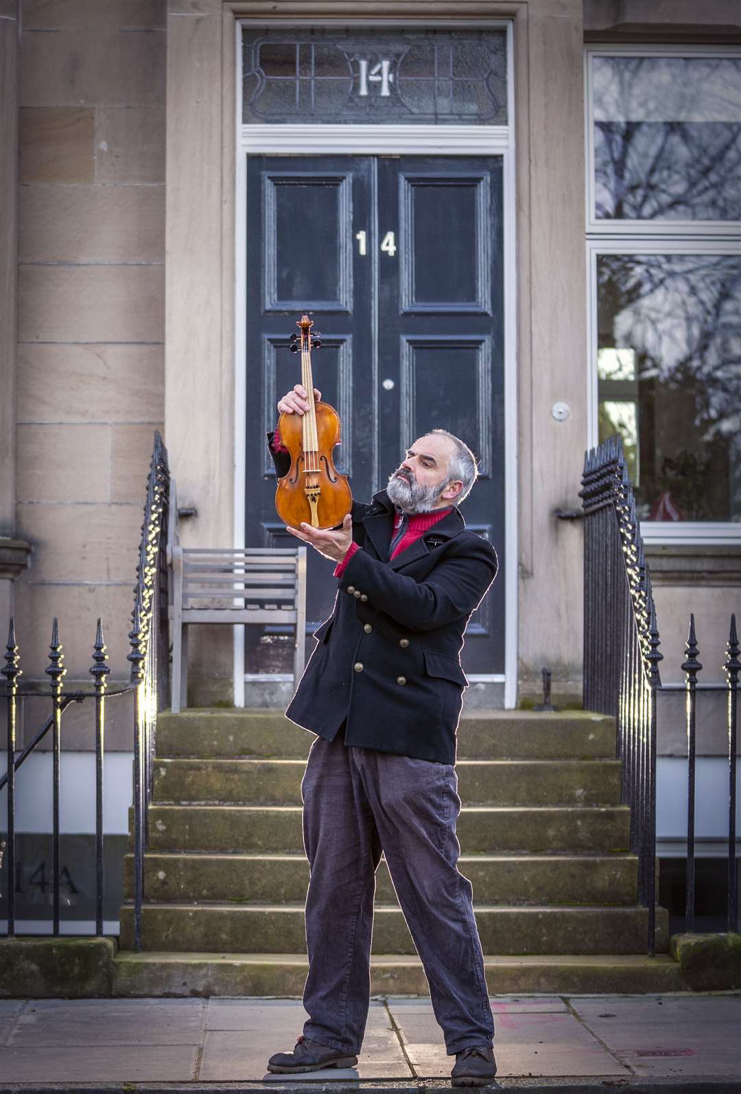 Steve Burnett holds the Ernest Shackleton Driftwood Violin, made to mark the centenary of the polar explorer’s death on January 5 1922, outside Shackleton’s Edinburgh home in South Learmonth Gardens (Jane Barlow/PA)