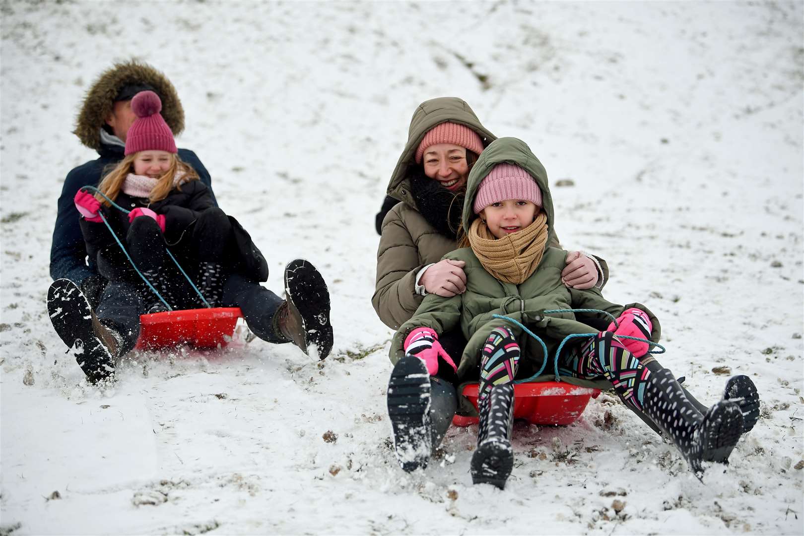 A group of people ride sledges in the snow in Essex (Victoria Jones/PA)