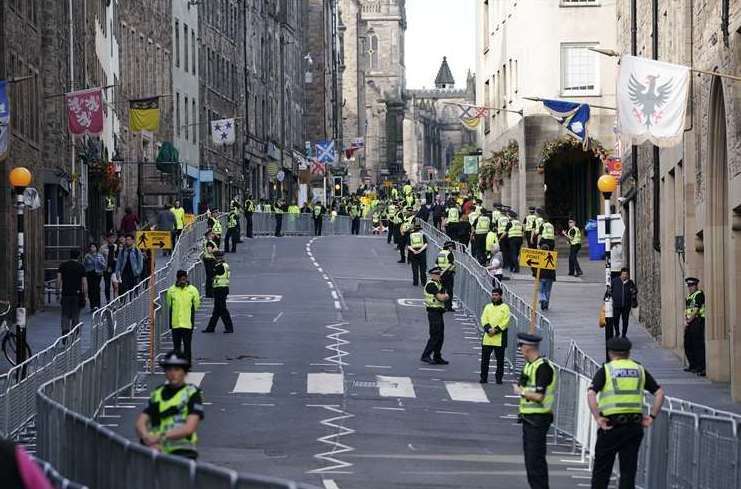 Police officers on the Royal Mile in Edinburgh prepare for the cortege. Picture: Peter Byrne/PA