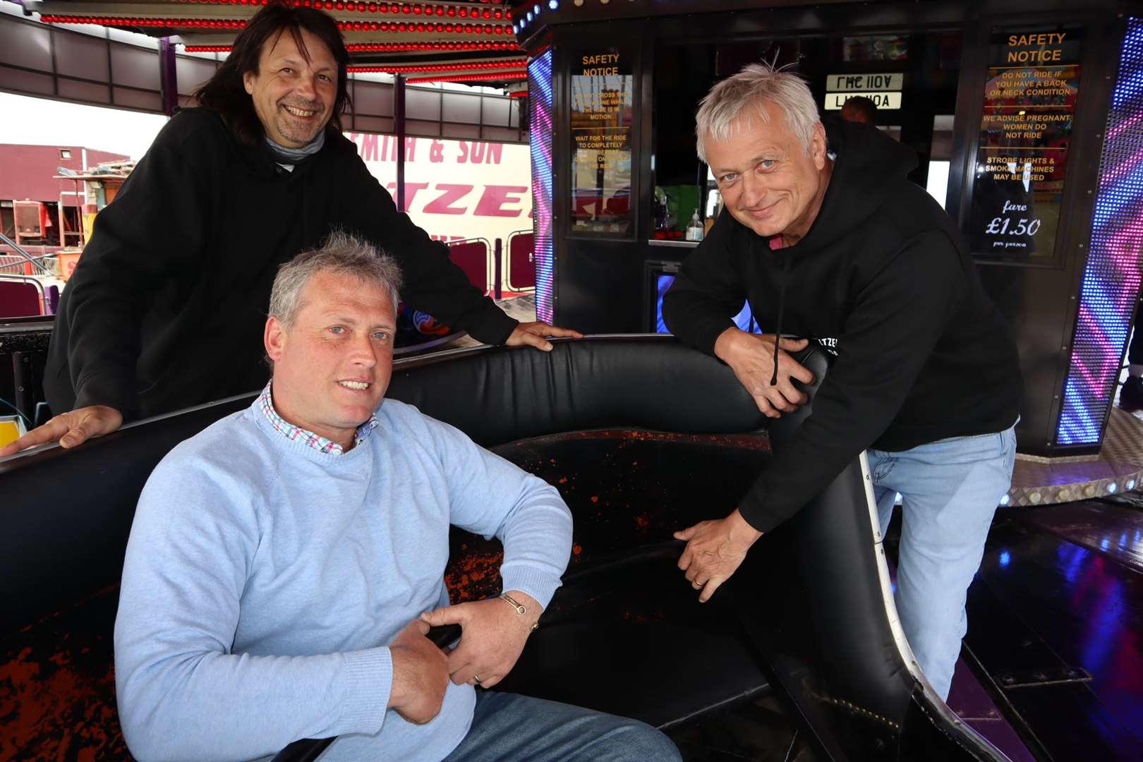 Cllrs Mike Baldock, left, and Richard Palmer give funfair boss Carlos Christian a hand on the waltzer at Smith's funfair at Barton's Point, Sheerness