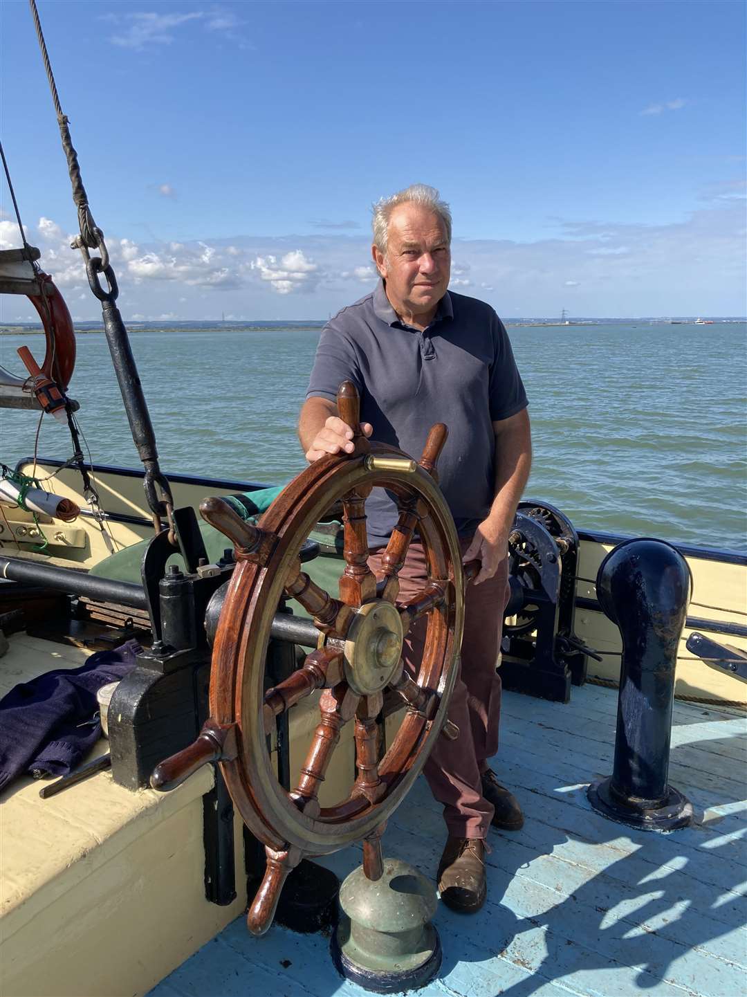 Skipper Geoff Gransden at the wheel of the Thames sailing barge the Edith May off Sheppey