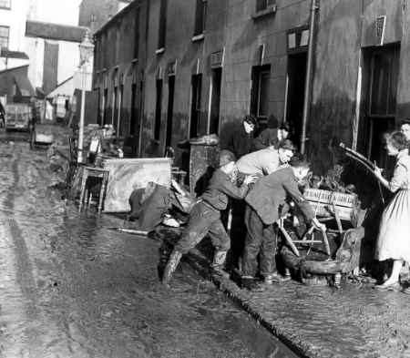 DOMESTIC WRECKAGE: Children sort out belongings salvaged from their flood damaged homes in Beach Street, Herne Bay: