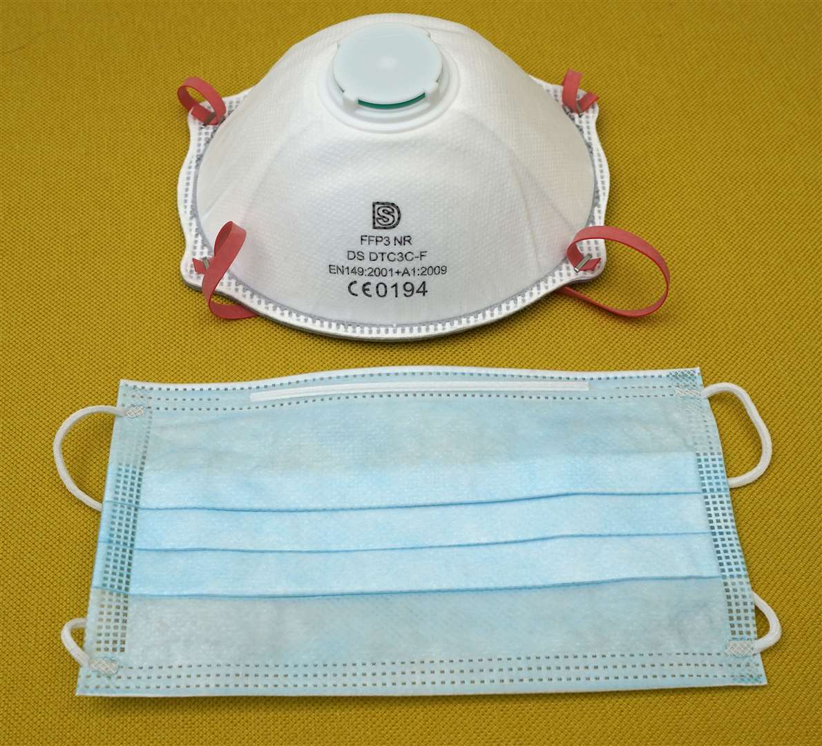 A filtering face piece 3 (FFP3) respirator (top) and a fluid resistant surgical mask (Peter Byrne/PA)