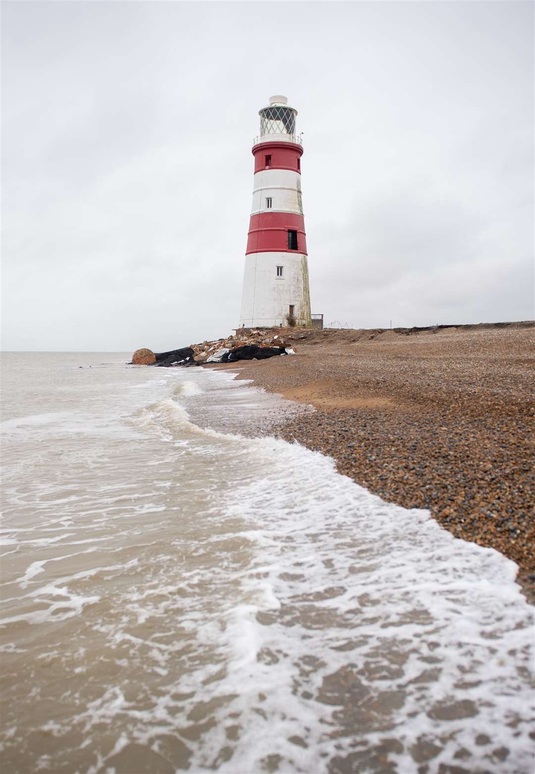 Waves lap the base of Orfordness lighthouse on the Suffolk coast (Joe Giddens/ PA)