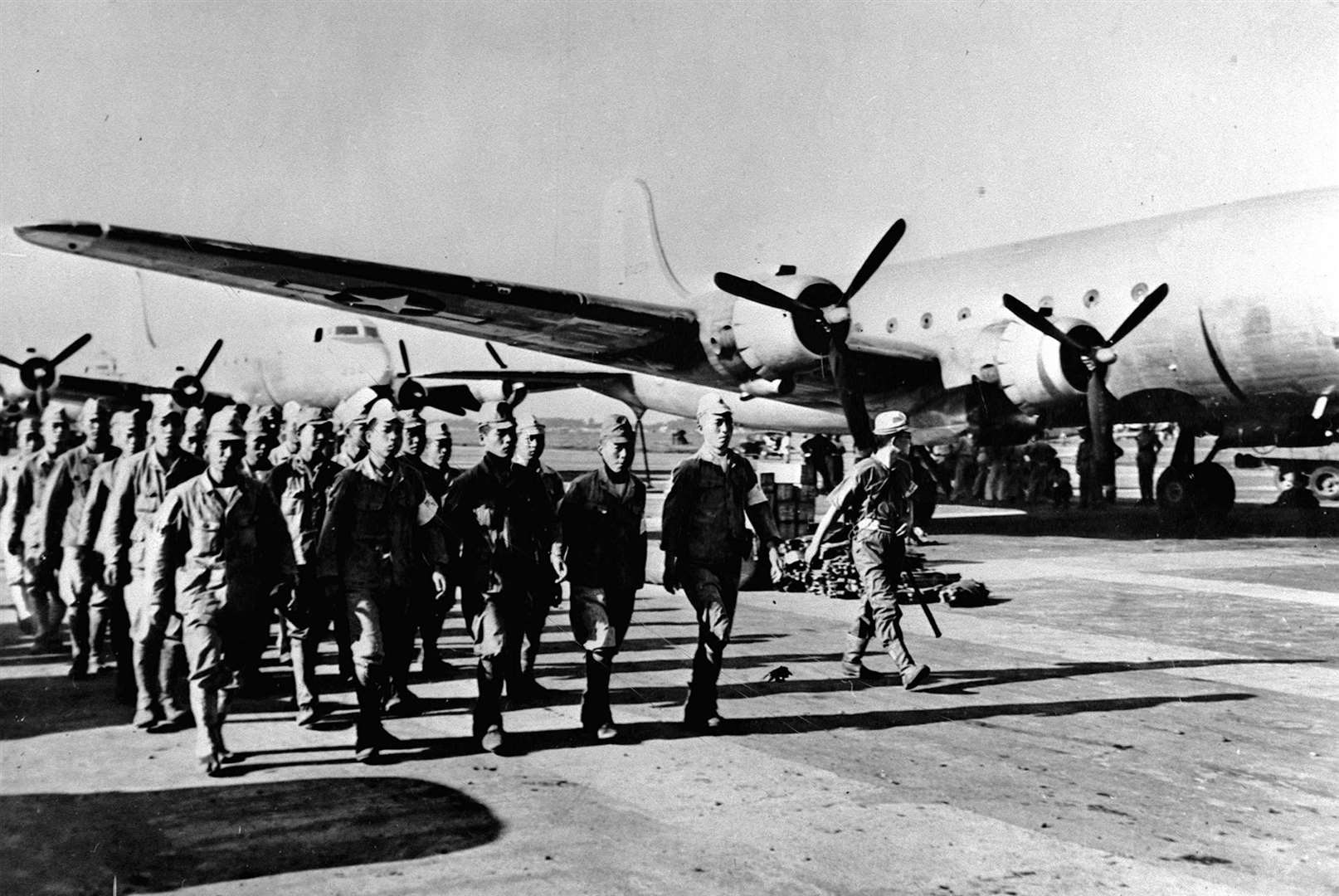 Having surrendered, Japanese soldiers march in formation past American occupation forces on Atsugi airfield at the end of the Second World War, circa August 1945 (PA)