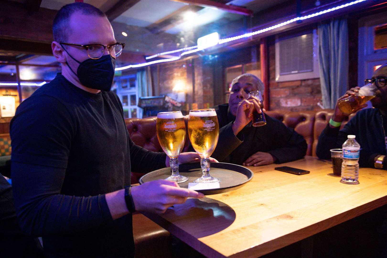 A man carries a tray of drinks to a table at the The Oak Inn in Coventry (PA)