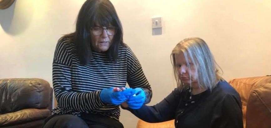 Care manager Sharon Head gives a service user a manicure while in 'lockdown'