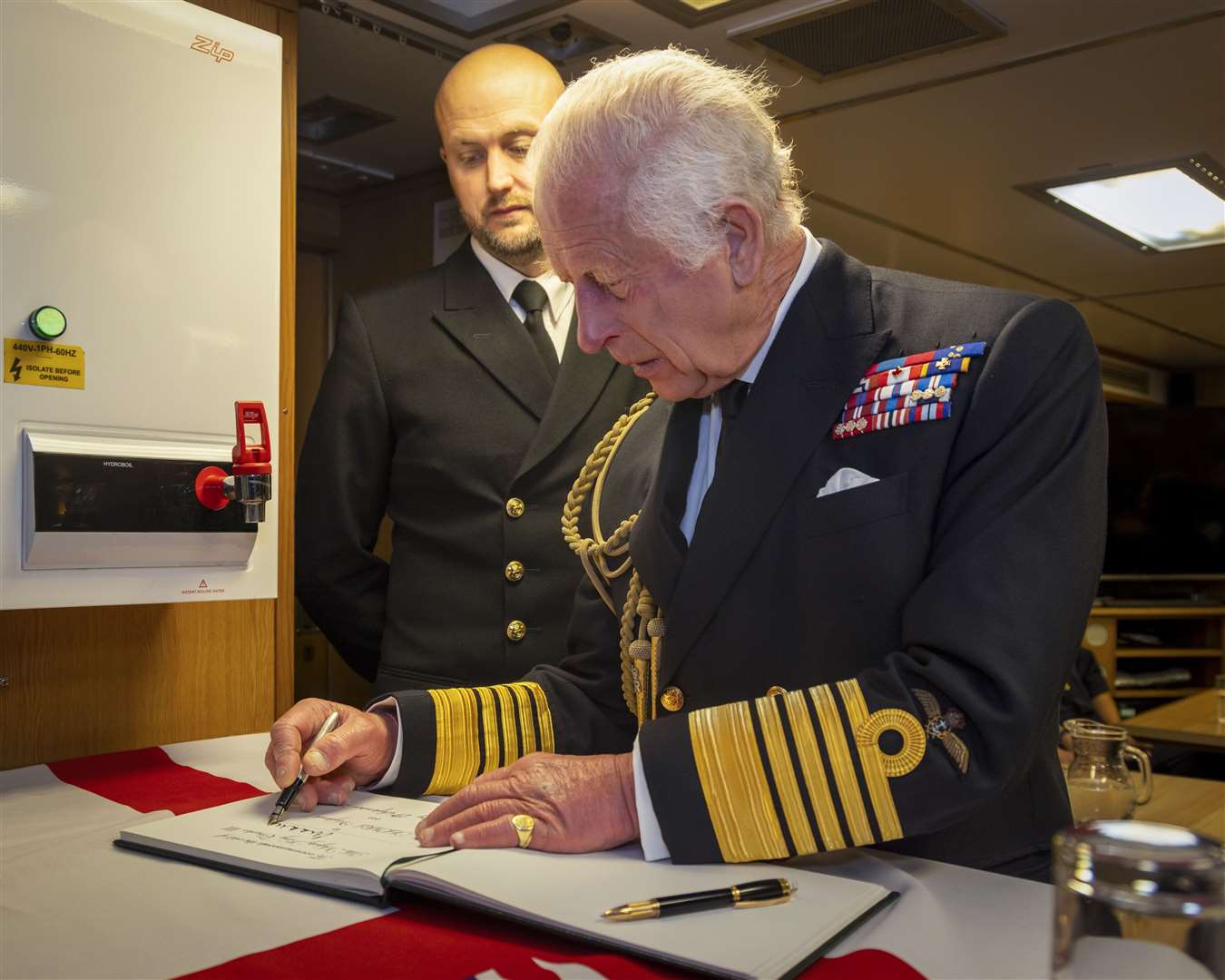 The King signing the visitors’ book during a visit to the Royal Naval Armaments Depot at Coulport (LPhot Stuart Dickson/MoD/Crown Copyright/PA)