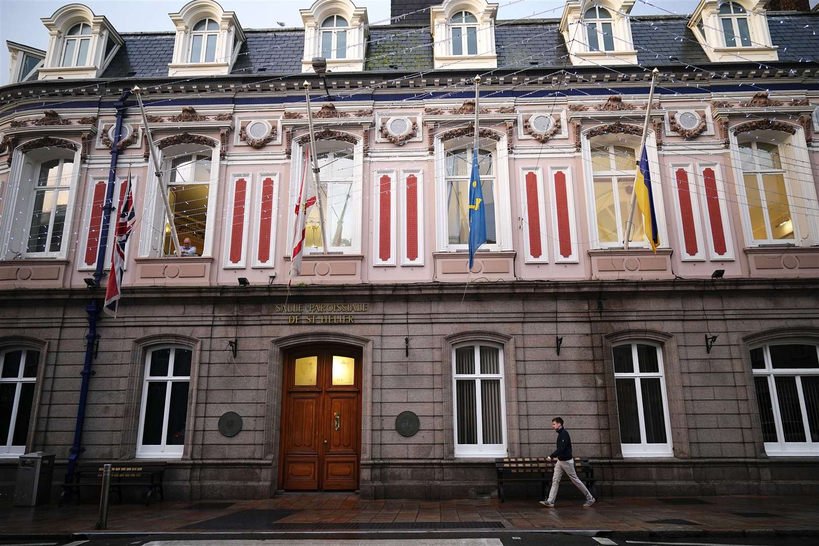 The Union flag, the flag of Jersey, the flag of St Helier and the Ukrainian flag are lowered to half-mast over St Helier Town Hall (Aaron Chown/PA)