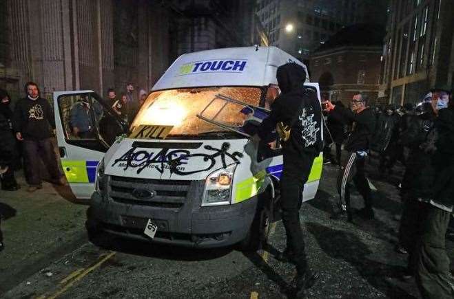 Protesters set fire to a vandalised police van outside the police station (Andrew Matthews/PA)