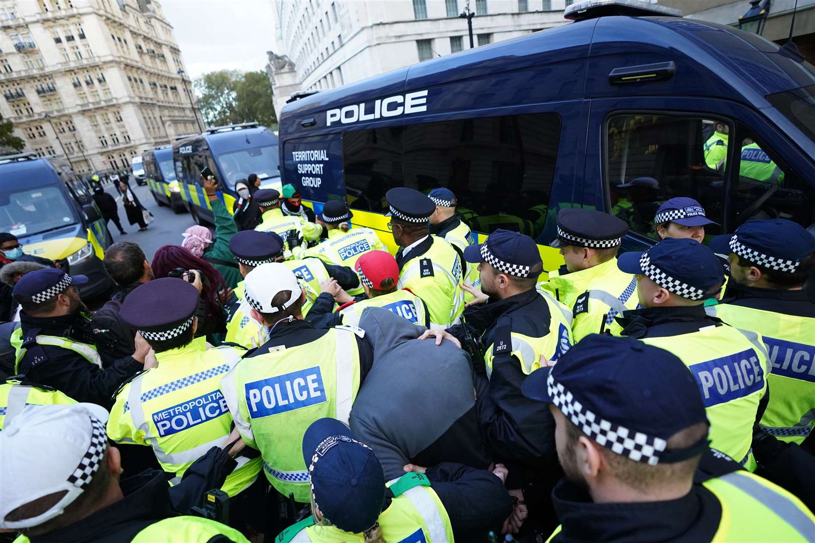 Police officers escort a protester who was arrested close to Downing Street during a March for Palestine in London (James Manning/PA)