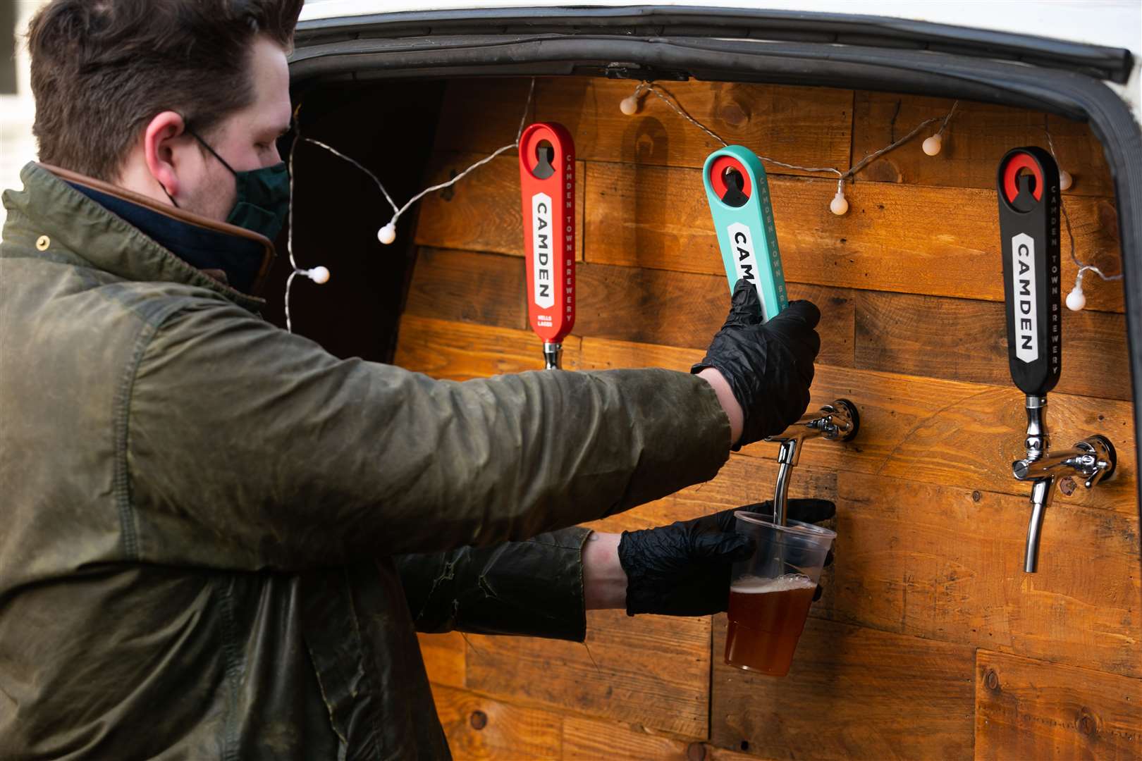 George Dean, a former bar manager pours a pint with his pub-on-wheels in Clapham, south London (Aaron Chown/PA)